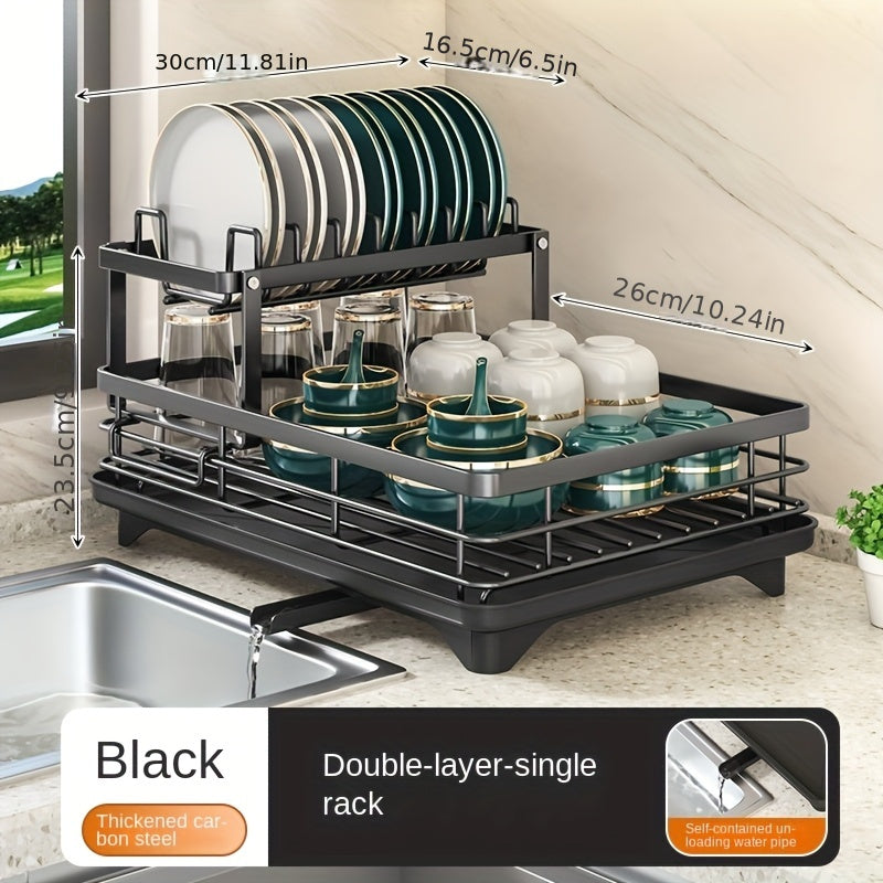 Modern two-tier metal dish rack with drainboard in black carbon steel with golden accents. Detachable upper shelf and stackable design for plates, cups, and utensils on kitchen countertop.