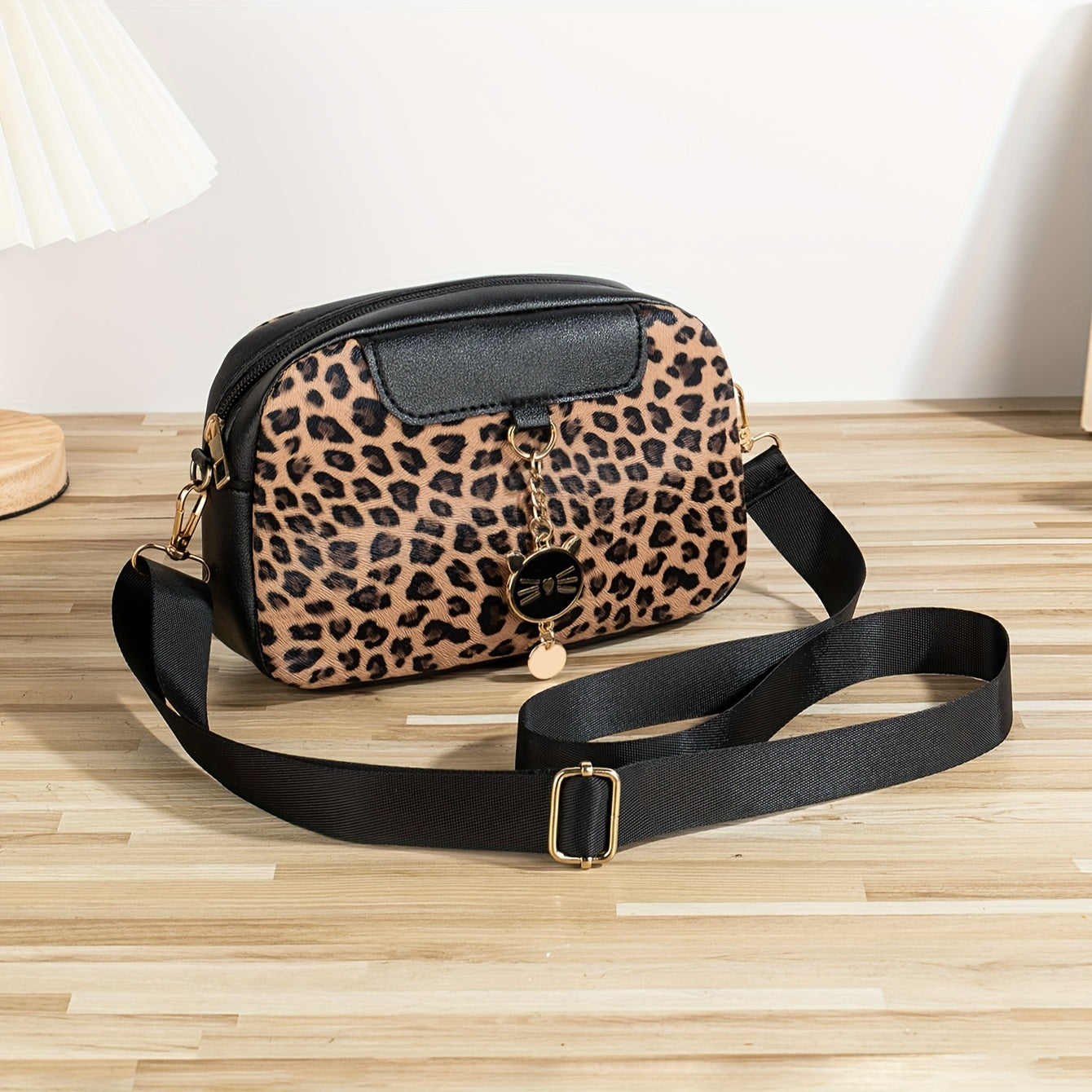 Chic leopard print crossbody bag with adjustable strap, cat charm, zip closure, and polyester lining - ideal for work, outings, and daily commutes.