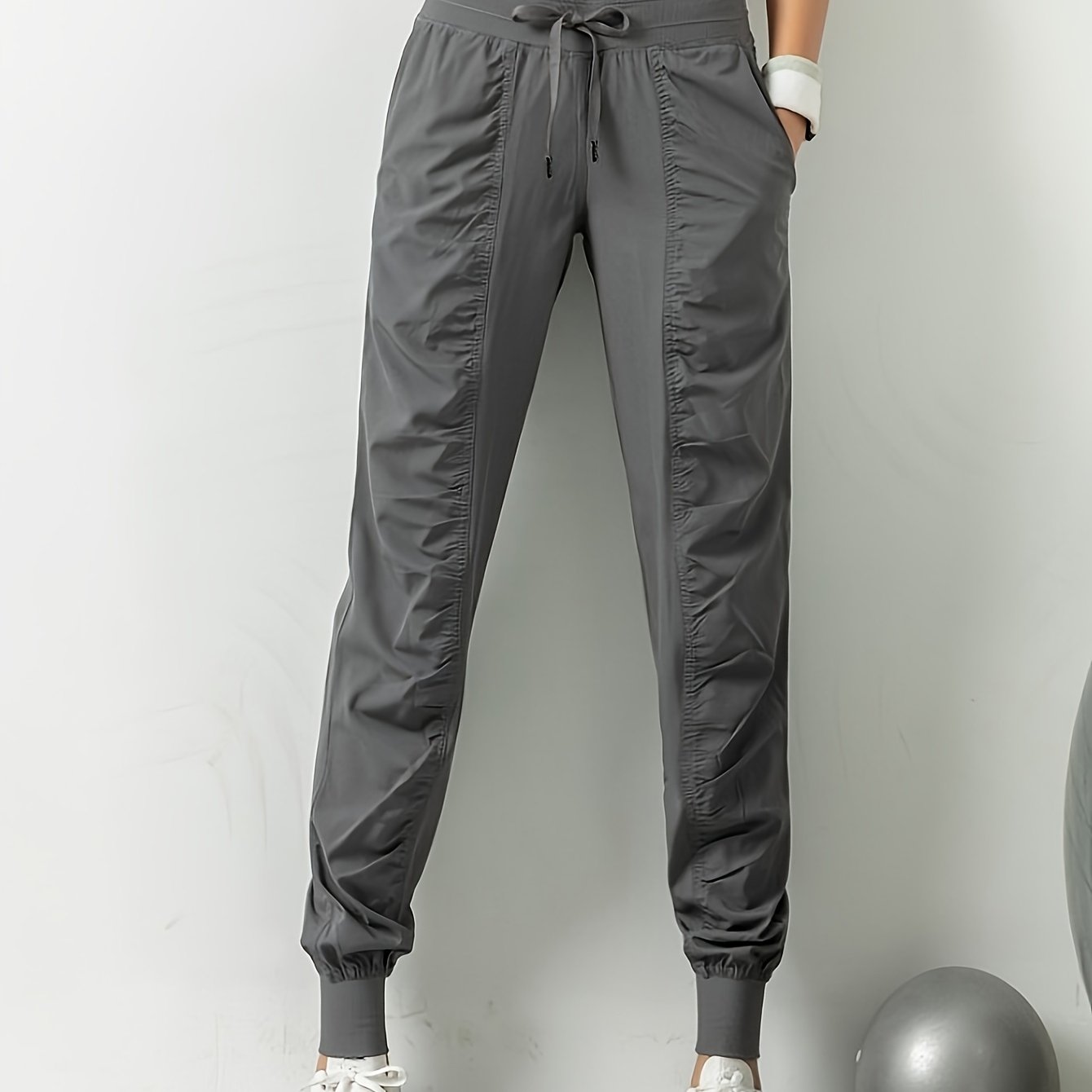 Women's solid color sports pants with drawstring waist, quick drying material, and side pockets for casual comfort.