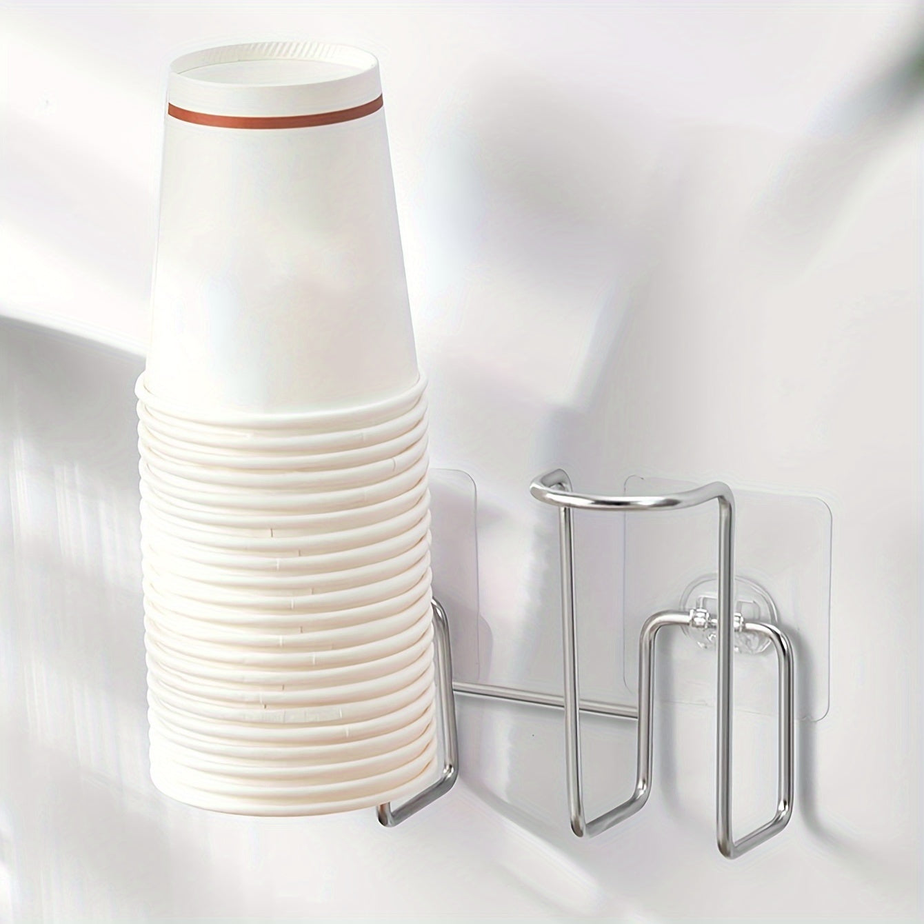 Wall mounted storage organizer for disposable paper cups, made of stainless steel and plastic. Suitable for use in offices, kitchens, and homes, this punch-free rack is designed to hold cups for water dispensers.