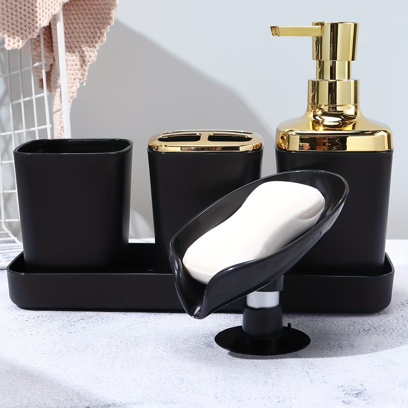 Stylish 5-piece black bathroom set with golden accents, includes lotion dispenser, toothbrush holder, cup, soap dish, and tray made of sleek plastic for elegant home decor.