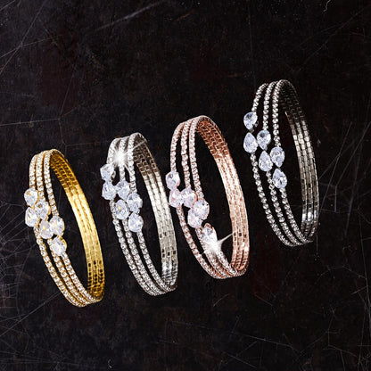 This stunning bracelet showcases a trendy multi-layer water droplet design, embellished with synthetic zirconia for a touch of elegance. Its stylish and luxurious aesthetic caters to women who appreciate high-quality craftsmanship.