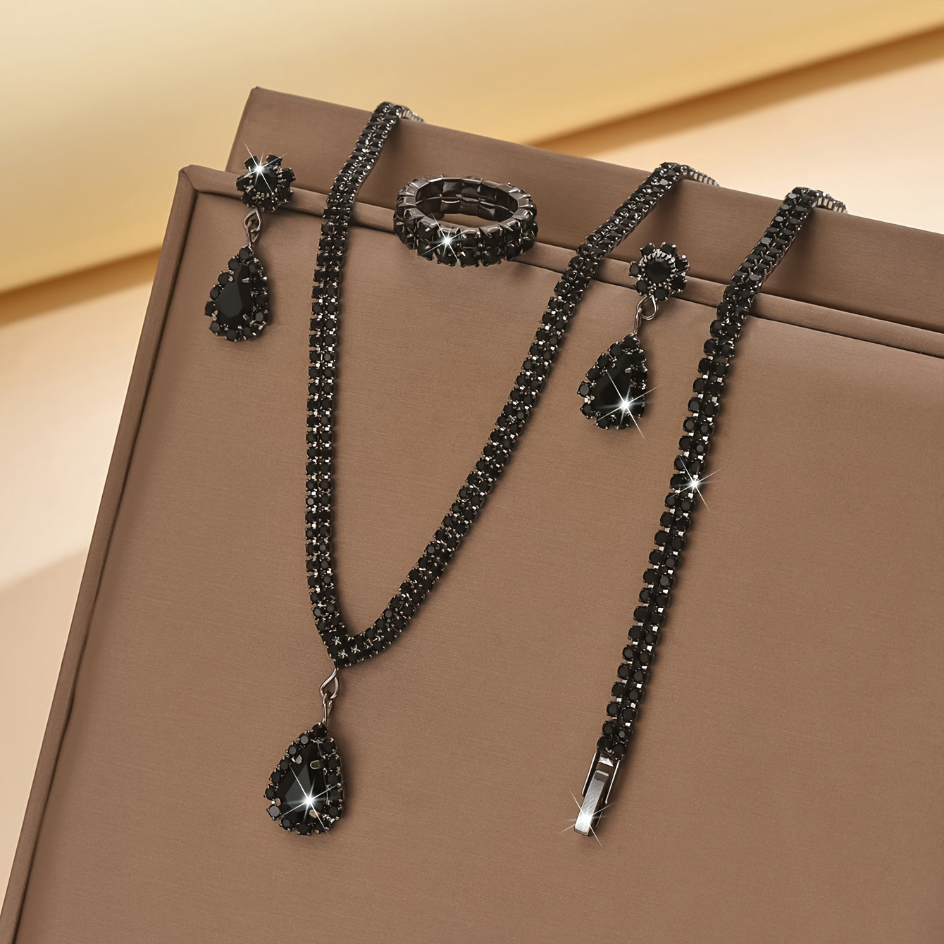 This sophisticated jewelry set features synthetic rhinestones set in silver-plated copper. Included in the set are a necklace, bracelet, earrings, and ring, perfect for weddings and parties. This stunning collection also makes a great Thanksgiving gift.