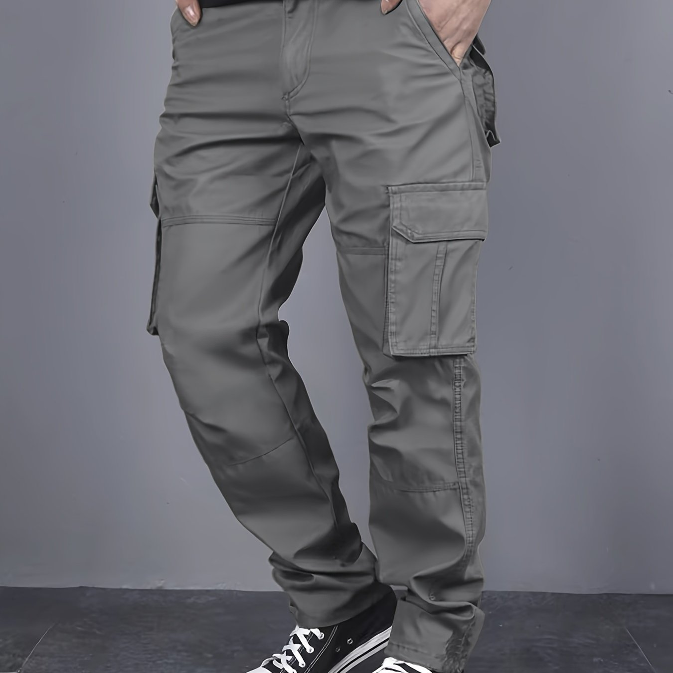 Solid color cargo pants with multiple flap pockets and a drawstring waistband, perfect for outdoor activities like hiking, fishing, and camping.