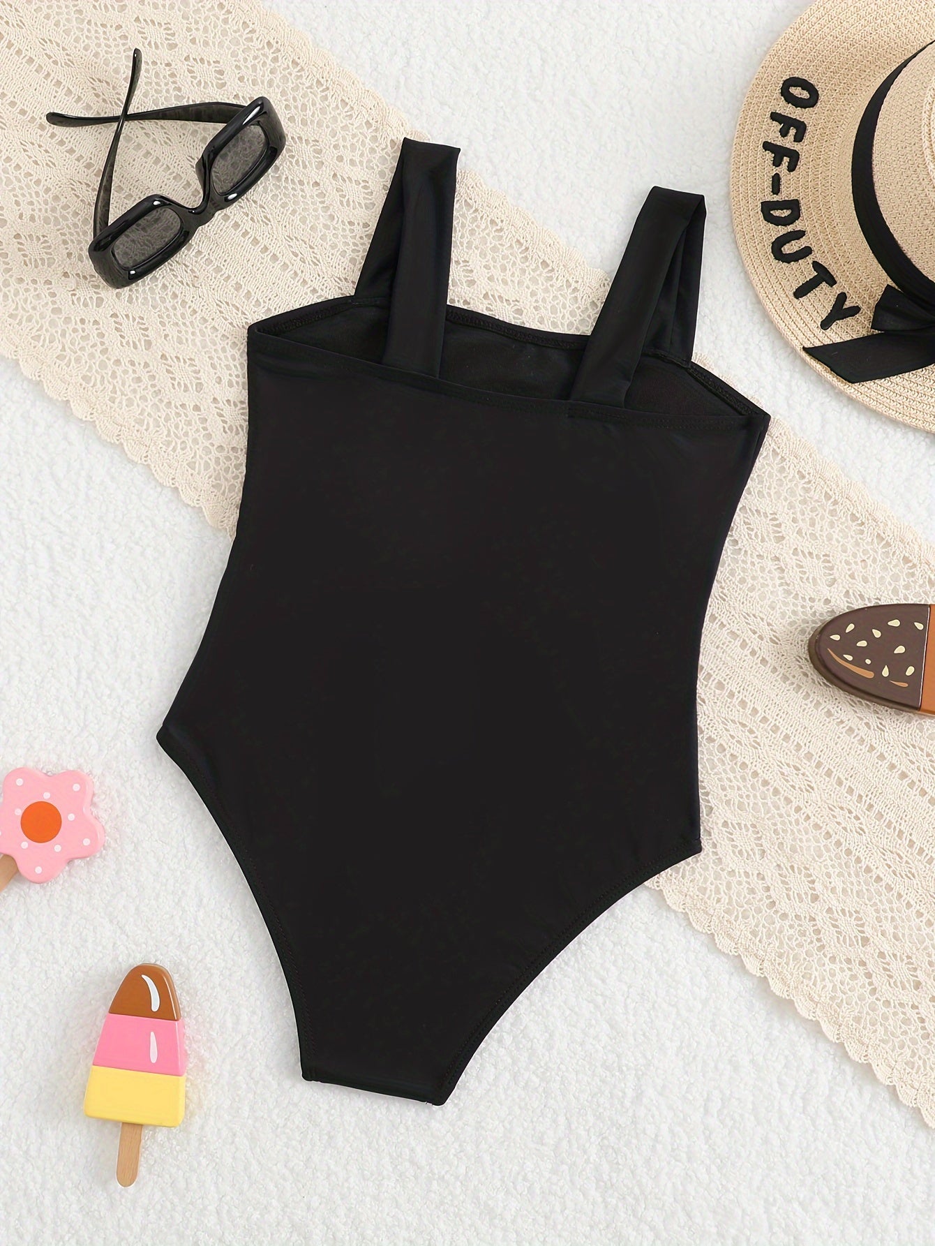 Chic girls' one-piece swimsuit with hollow design, wide straps, ideal for older kids at the beach.