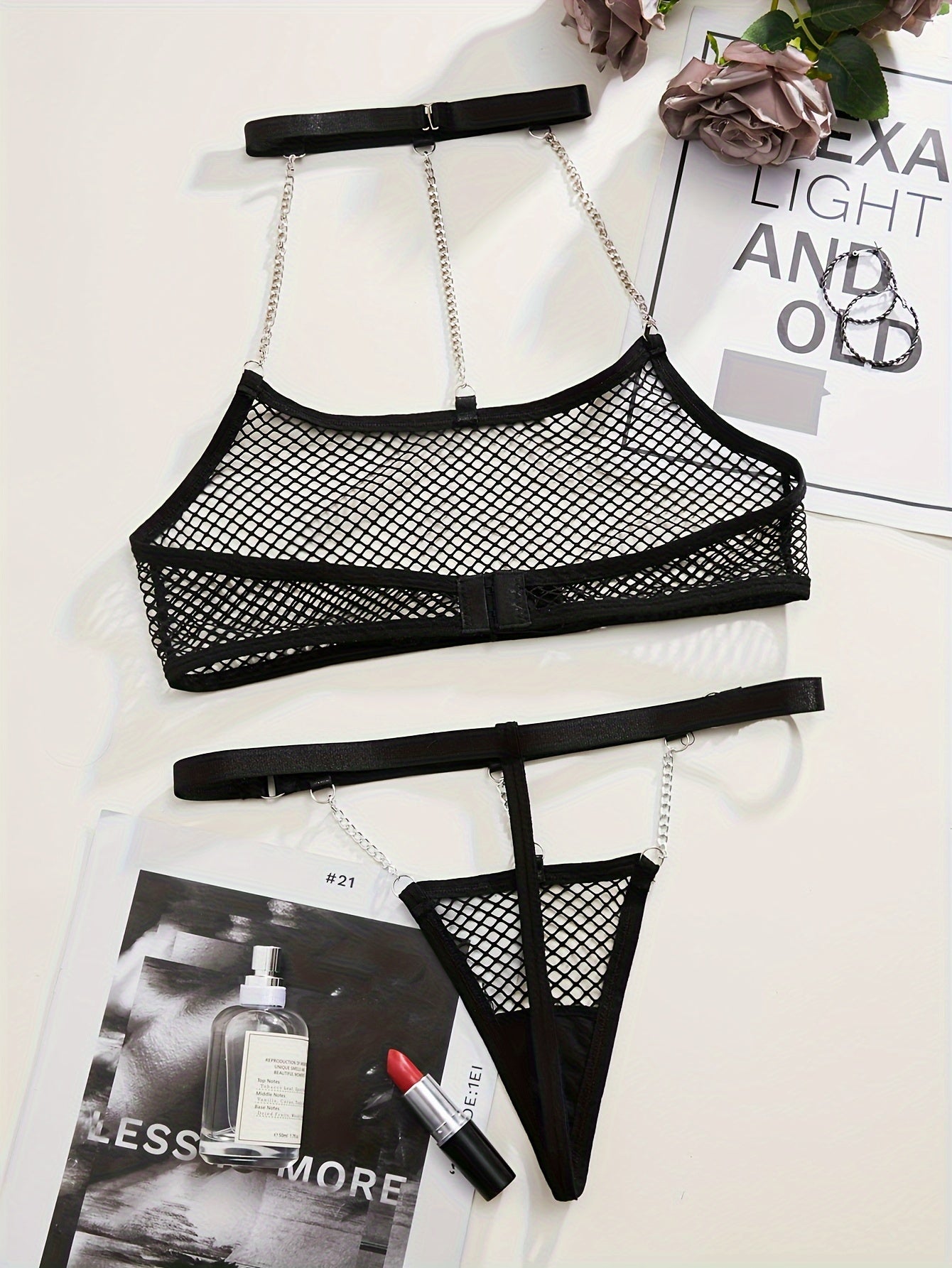 Black mesh lingerie set with metal chain straps, perfect for a seductive night in bed