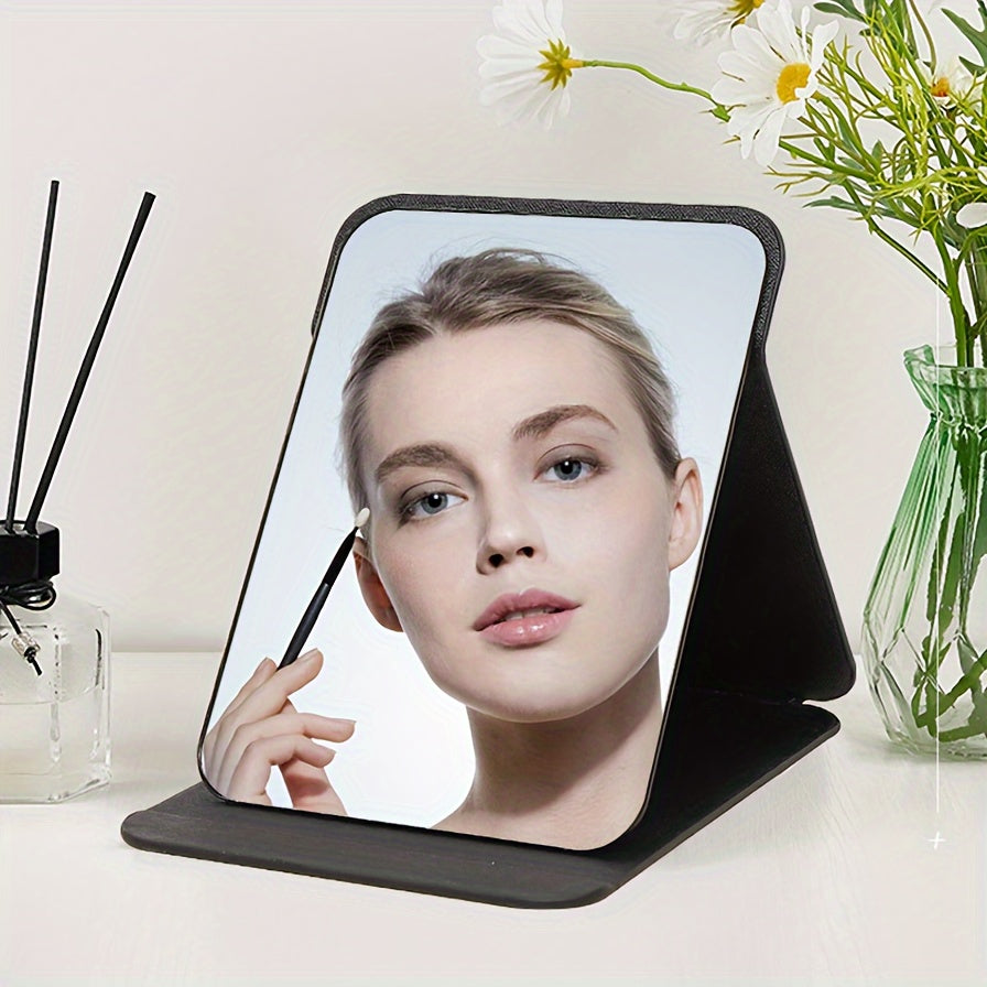 Stylish black foldable makeup mirror, great for desk, bedroom, and bathroom decor. Ideal for travel and makes a unique gift for weddings, parties, and birthdays. Glass surface with polished finish.