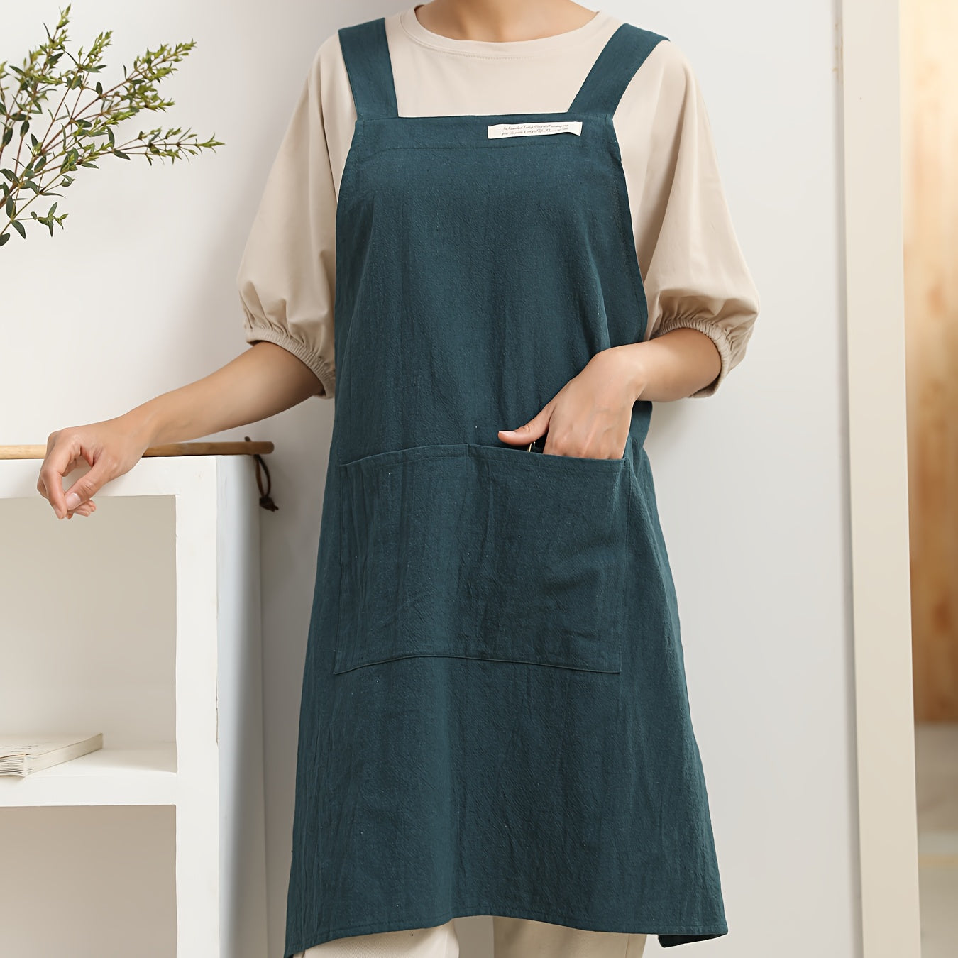 1 linen apron with cross straps and pockets for use in gardening, cooking, baking, painting, barista work, and other tasks.