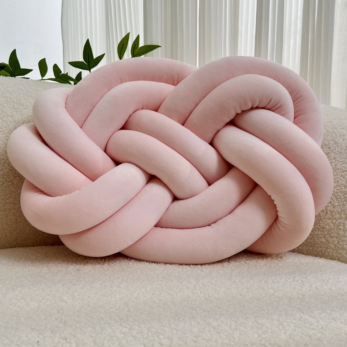 Knotted throw pillow for home decor, suitable for bed or sofa.