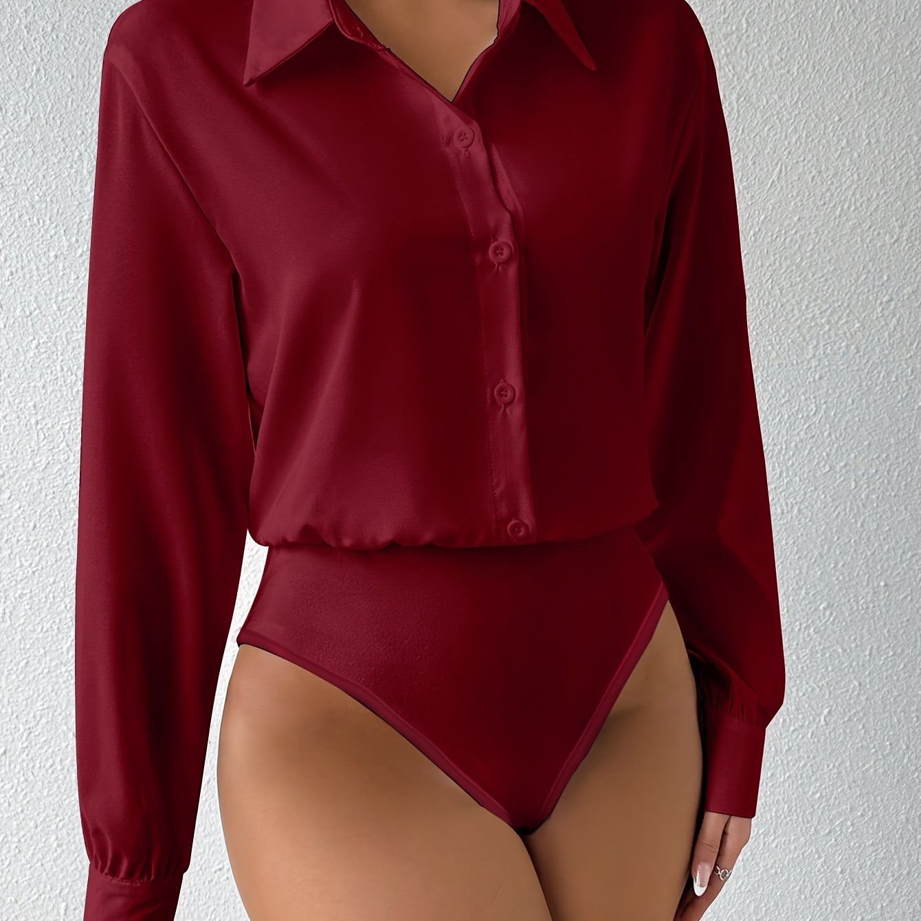 Elegant solid color collared bodysuit for women with button front and long sleeves.