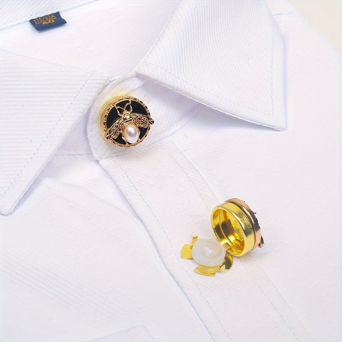 Get a pair of elegant Golden Bee cufflinks and shirt buttons set for a fashionable and seamless look. Made of shiny copper, these clip-on buttons are perfect for formal tailcoat attire and add a touch of luxurious decoration to your clothing. This fancy