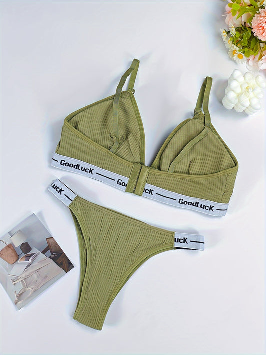 Womens sports lingerie set without underwire, with removable pads and mid-rise briefs. Made of polyester, cotton, and elastane blend with letter band detail.