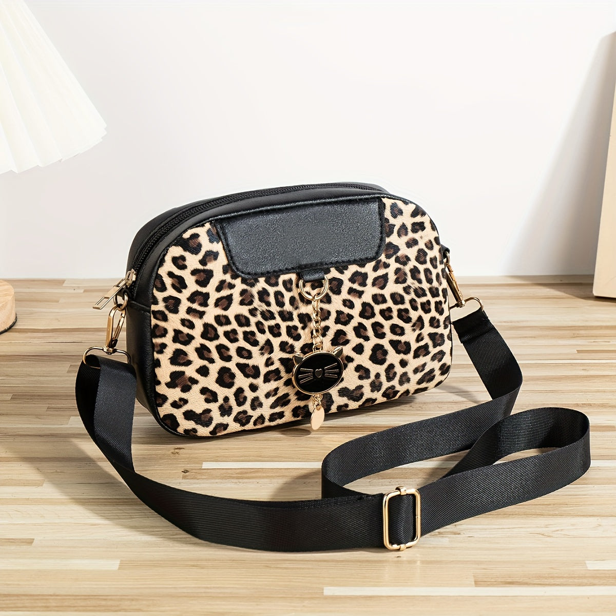 Chic leopard print crossbody bag with adjustable strap, cat charm, zip closure, and polyester lining - ideal for work, outings, and daily commutes.