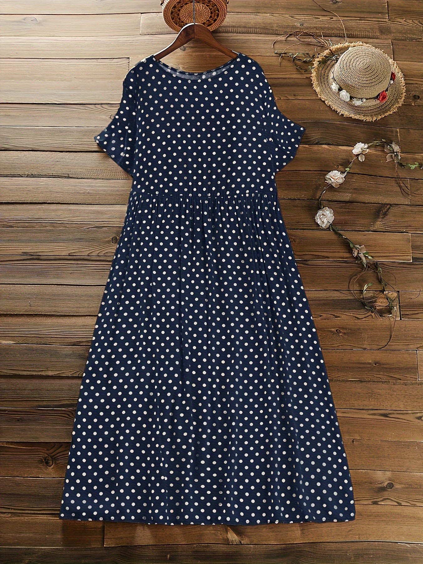 Machine washable navy blue midi dress with white polka dots, short sleeves, round neck, and ruffle detail.