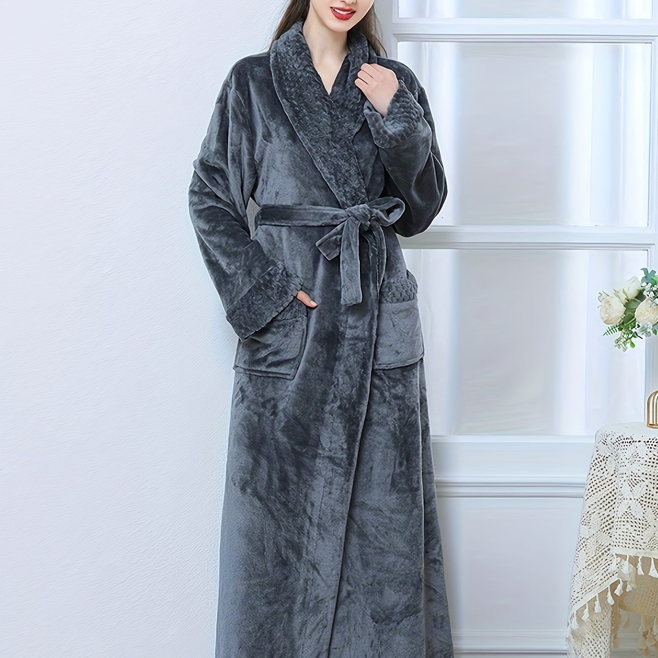 Plush pink flannel bathrobe for women with long sleeves, V-neck, and pockets. Machine washable for winter warmth.