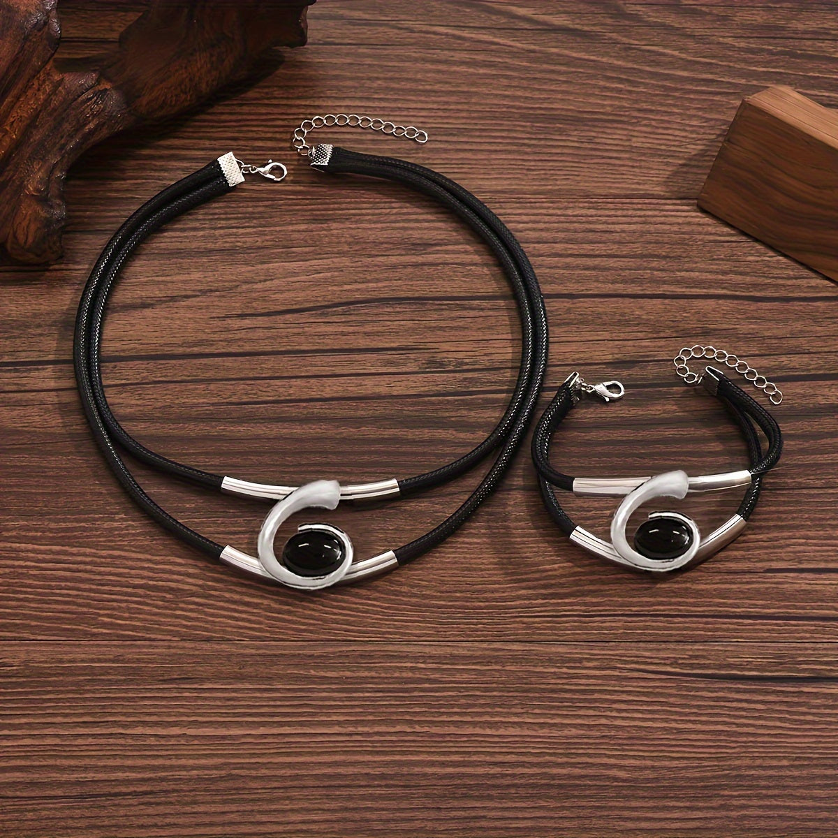 Set of two stylish double-row black imitation PU braided rope bracelets with metal pipe accents, paired with a black resin geometric spiral necklace and bracelet set. Perfect for women to wear as versatile daily or party jewelry.