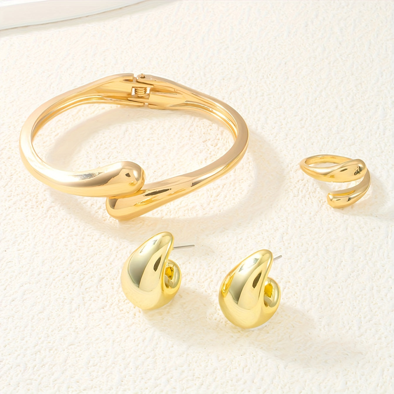 A set of women's jewelry, including earrings, a ring, and a bracelet with a spring design, ideal for everyday elegance.