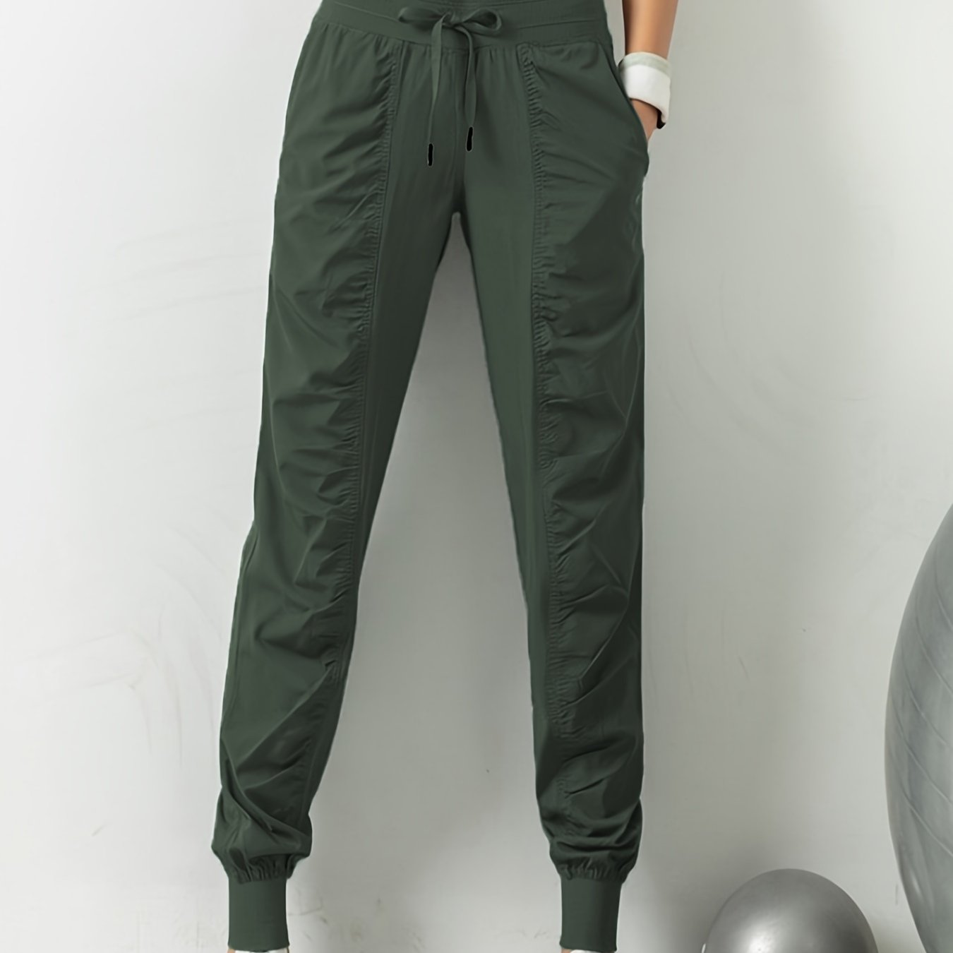 Women's solid color sports pants with drawstring waist, quick drying material, and side pockets for casual comfort.