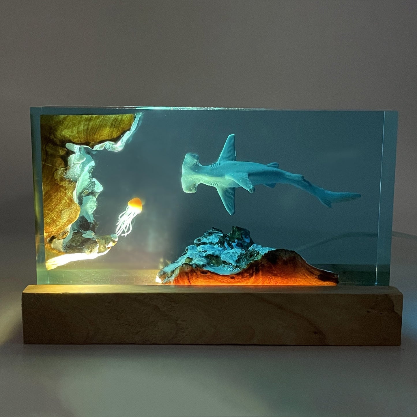 USB-powered decorative lamp with hammerhead shark and jellyfish design features realistic sea life scene and multi-room compatibility.