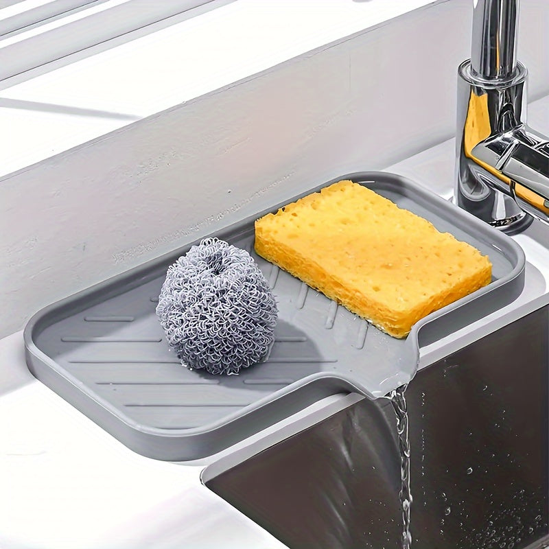 Silicone soap dish with self-draining tray for kitchen or bathroom sink, also functions as a non-slip sponge holder and soap saver pad.