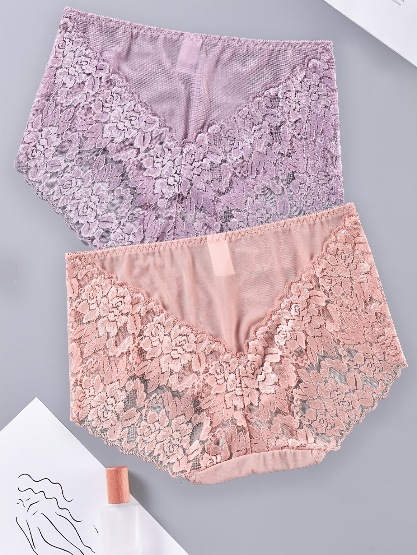 Two-pack plus-size lace panties for women made of 90% polyamide and 10% elastane. Features a medium-stretch knit fabric with a hollow floral pattern. Breathable, comfortable, and embodies a