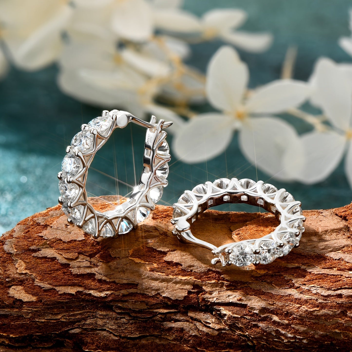 A pair of stunning Moissanite earrings crafted in 925 sterling silver feature a full circle round design with 3mm and 4mm Moissanite stones. The row set earrings have an inner diameter of 13mm, making them the perfect addition to any jewelry collection.