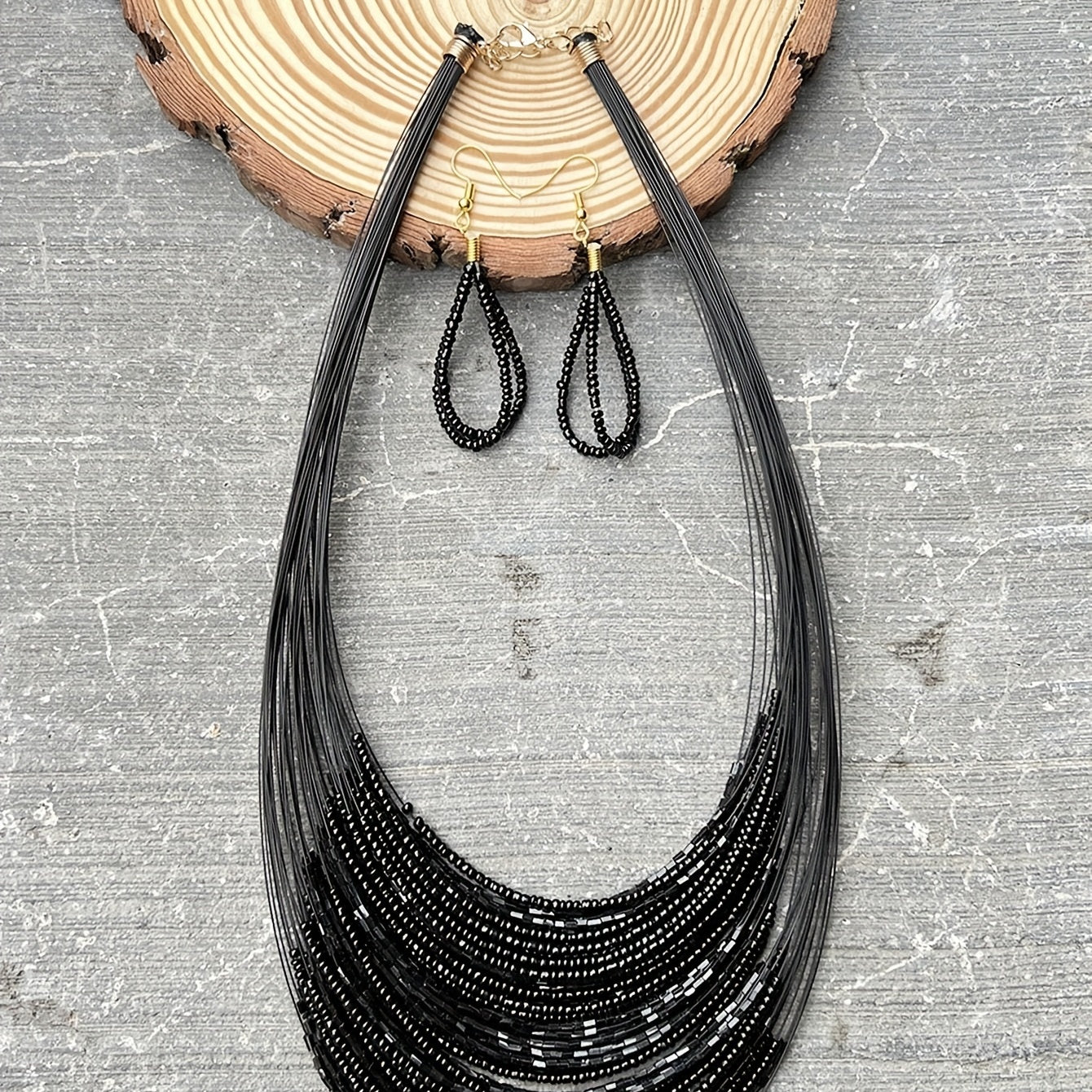 A set of three handmade earrings and a necklace crafted from elegant black beads in a multi-layer design, representing both evil and mystery. Perfect accessories to complete your daily outfits or add flair to your party attire.