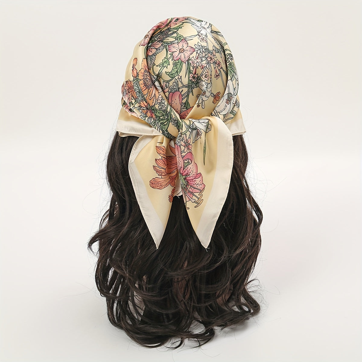 Boho floral print square scarf with tropical leaf and flower design on a light pink base. Perfect for outdoor use as a windproof hair accessory. Features silky texture and bohemian style.