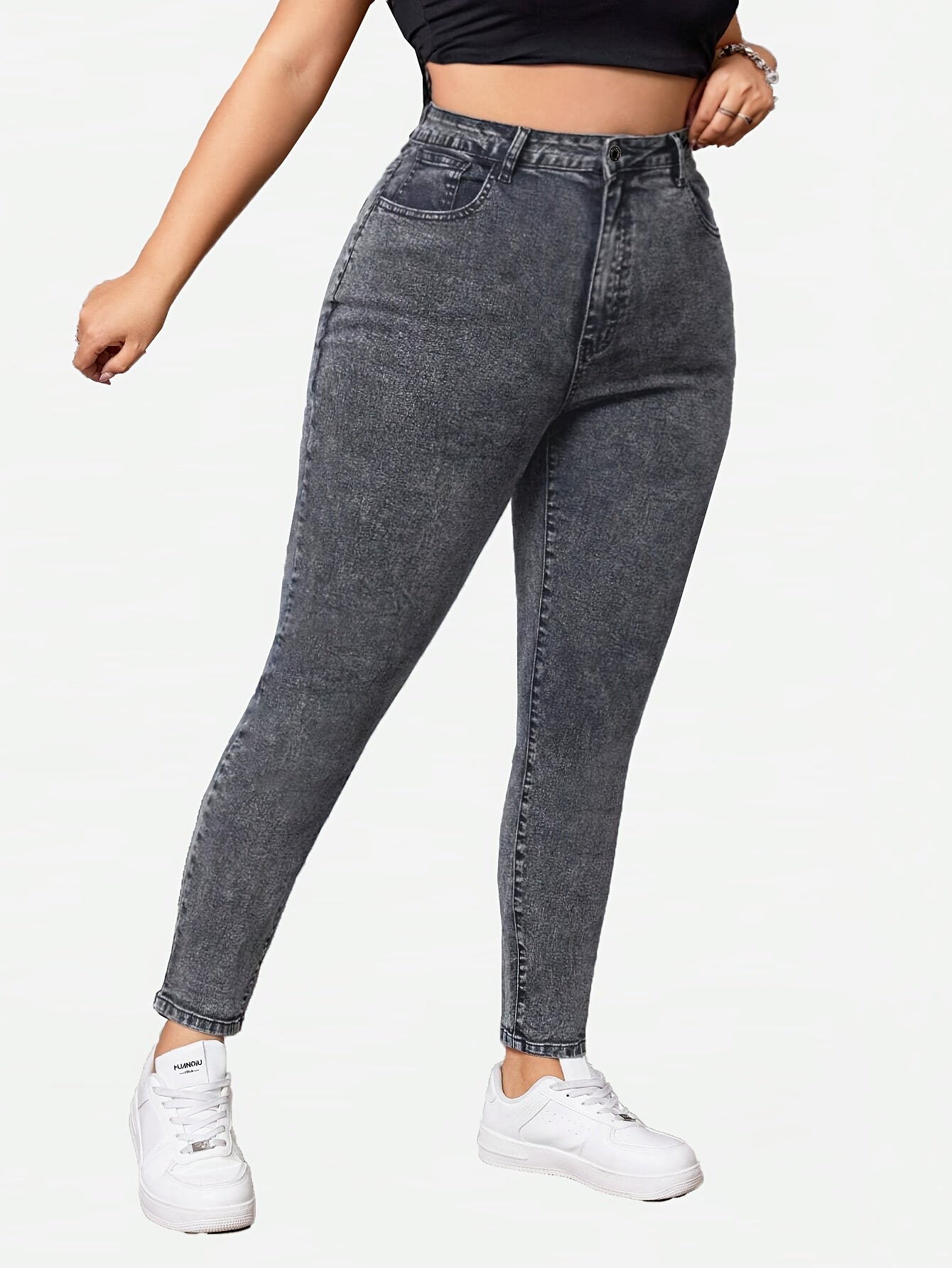 Plus-size high-waisted skinny jeans in heather gray washed denim with distressed detail. Made of 70% cotton, 27.6% polyester, and 2.4% spandex blend. Features elegant button fly, long