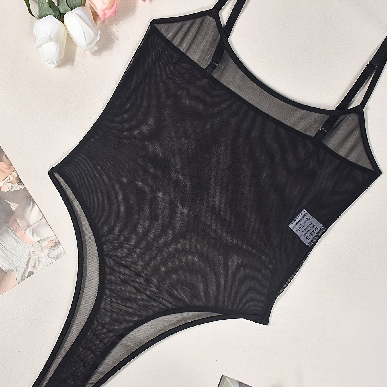 Sexy sheer bodysuit with floral accents and delicate straps, perfect for intimate moments.