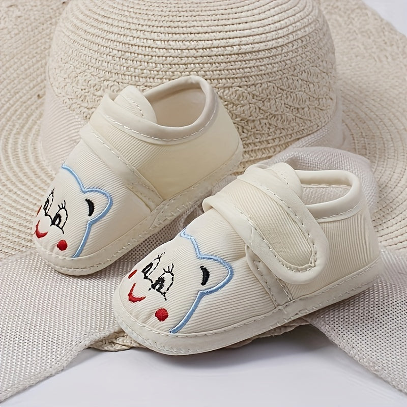 Cute baby walking shoes for boys and girls in light blue with cartoon faces, non-slip soles, and hook-and-loop closure. Ideal for first steps in any season.