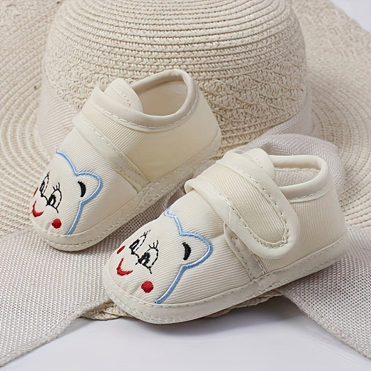 Cute baby walking shoes for boys and girls in light blue with cartoon faces, non-slip soles, and hook-and-loop closure. Ideal for first steps in any season.