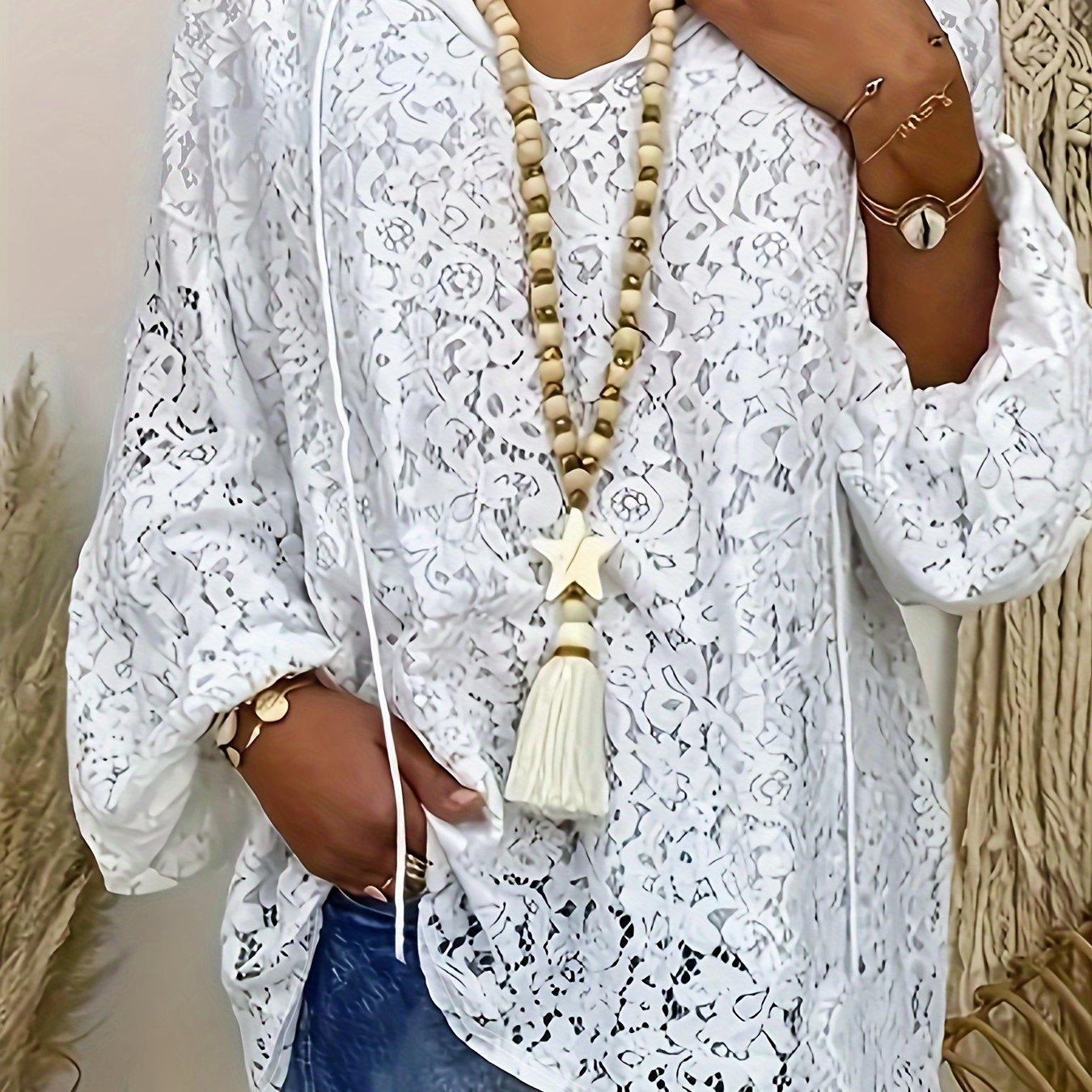 Plus size white V-neck long sleeve knit top with floral cut-out design, loose fit and lightweight polyester blend for summer wear. Features tassel necklace and lightweight knit fabric.