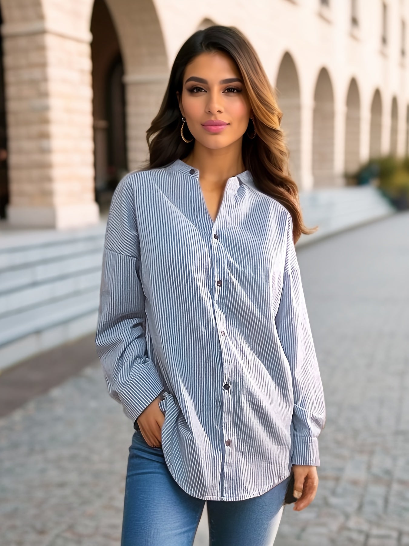 Women's striped shirt with drop shoulders, long sleeves, v-neck, and button closure.