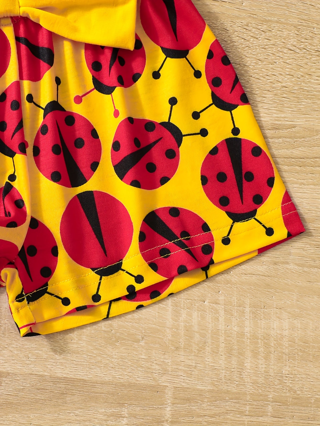 Ruffle sleeve graphic tee and ladybug shorts set for baby girl, perfect casual summer outfit.