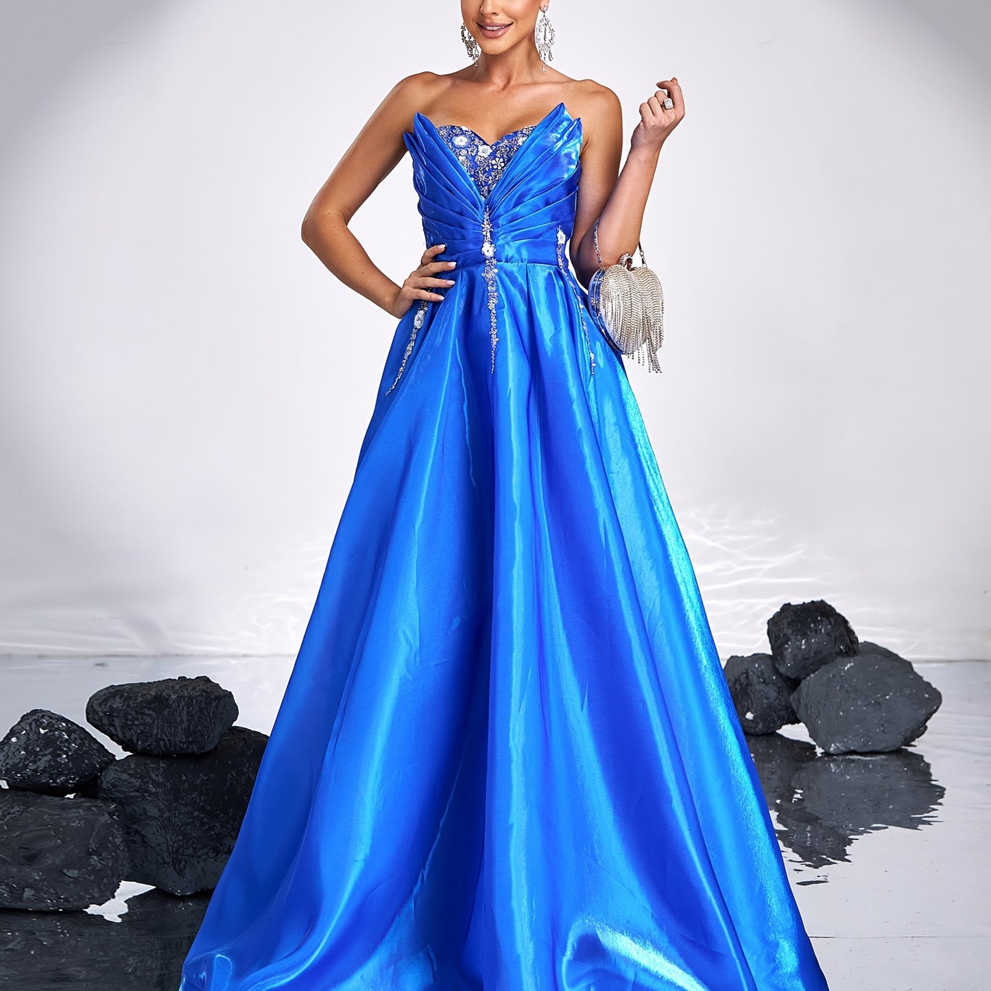 Elegant royal blue satin tube dress with rhinestone detailing and backless design, perfect for parties and formal events. Off-shoulder gown with flowing skirt and structured silhouette.