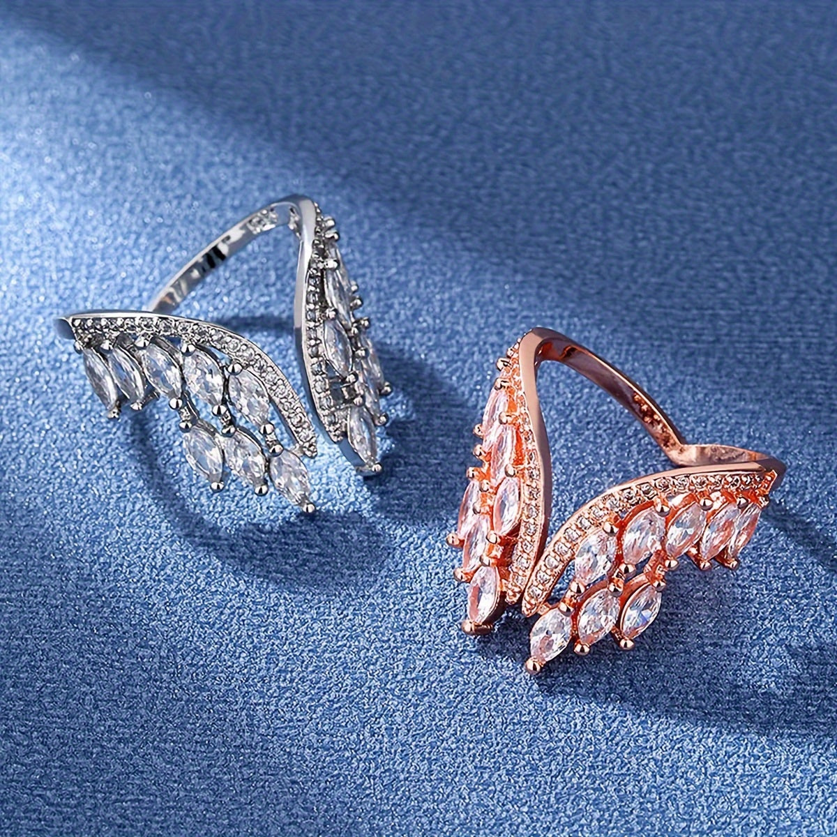 A pair of engagement and wedding rings and bracelets adorned with the wings of a female angel.