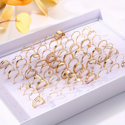 This stylish stackable ring set features 68 pieces adorned with faux pearls and cubic zirconia, showcasing elegant heart and butterfly designs. The rings are in a beautiful golden tone, perfect for everyday wear or special occasions. Perfect for adding a