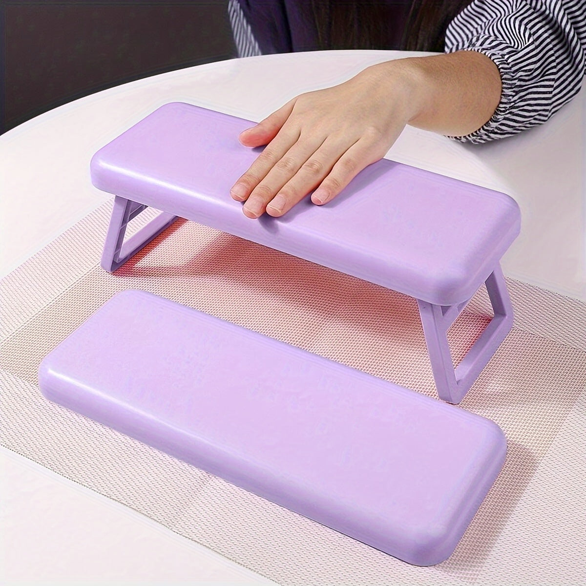 Single folding nail armrest for manicurists, with hand support and wrist rest for salon use.