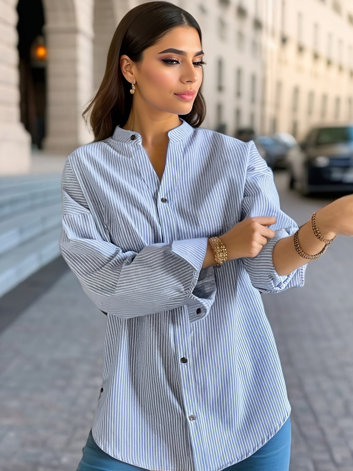 Women's striped shirt with drop shoulders, long sleeves, v-neck, and button closure.