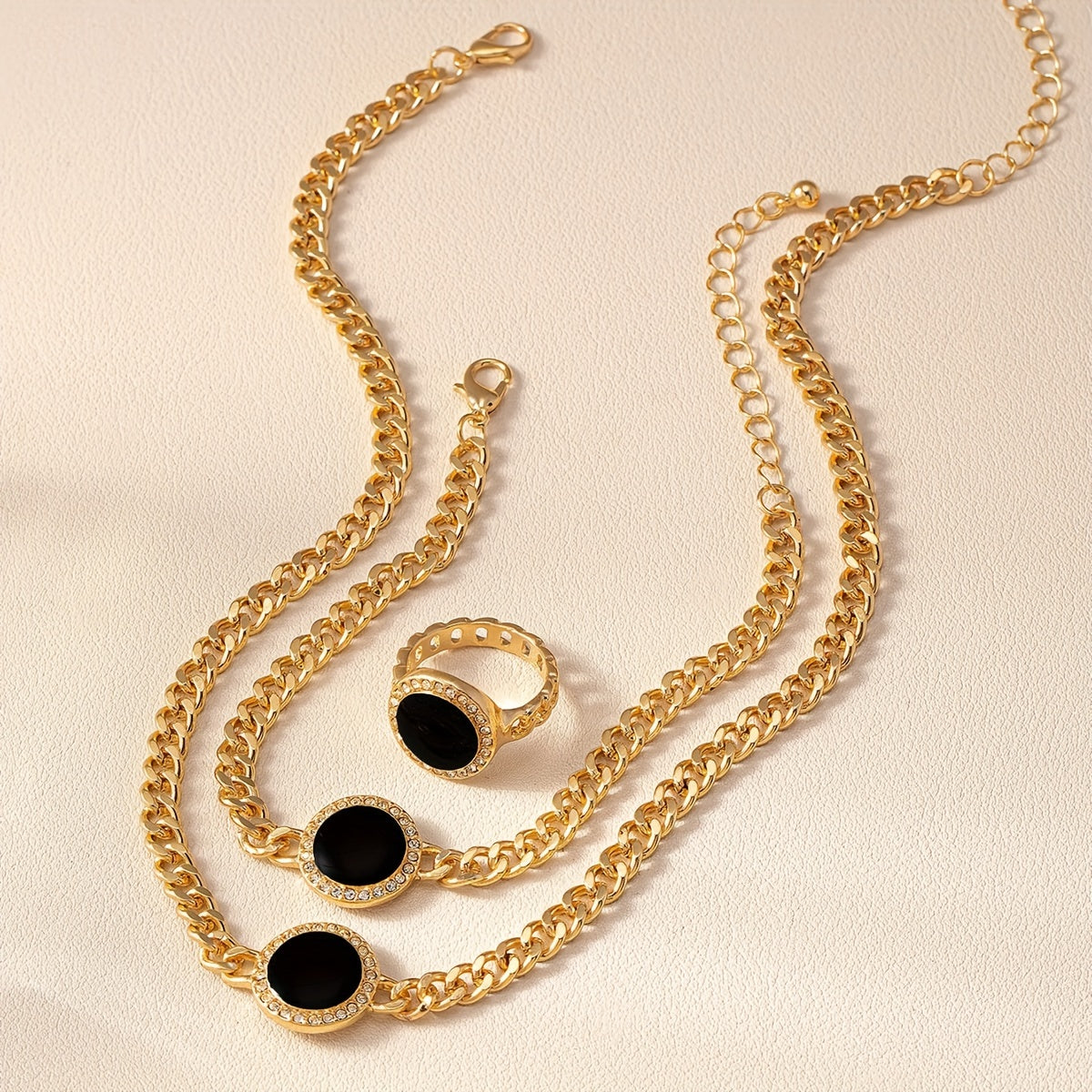 A collection of sleek and stylish black circular jewelry, including a necklace, ring, bracelet, and matching three-piece set.