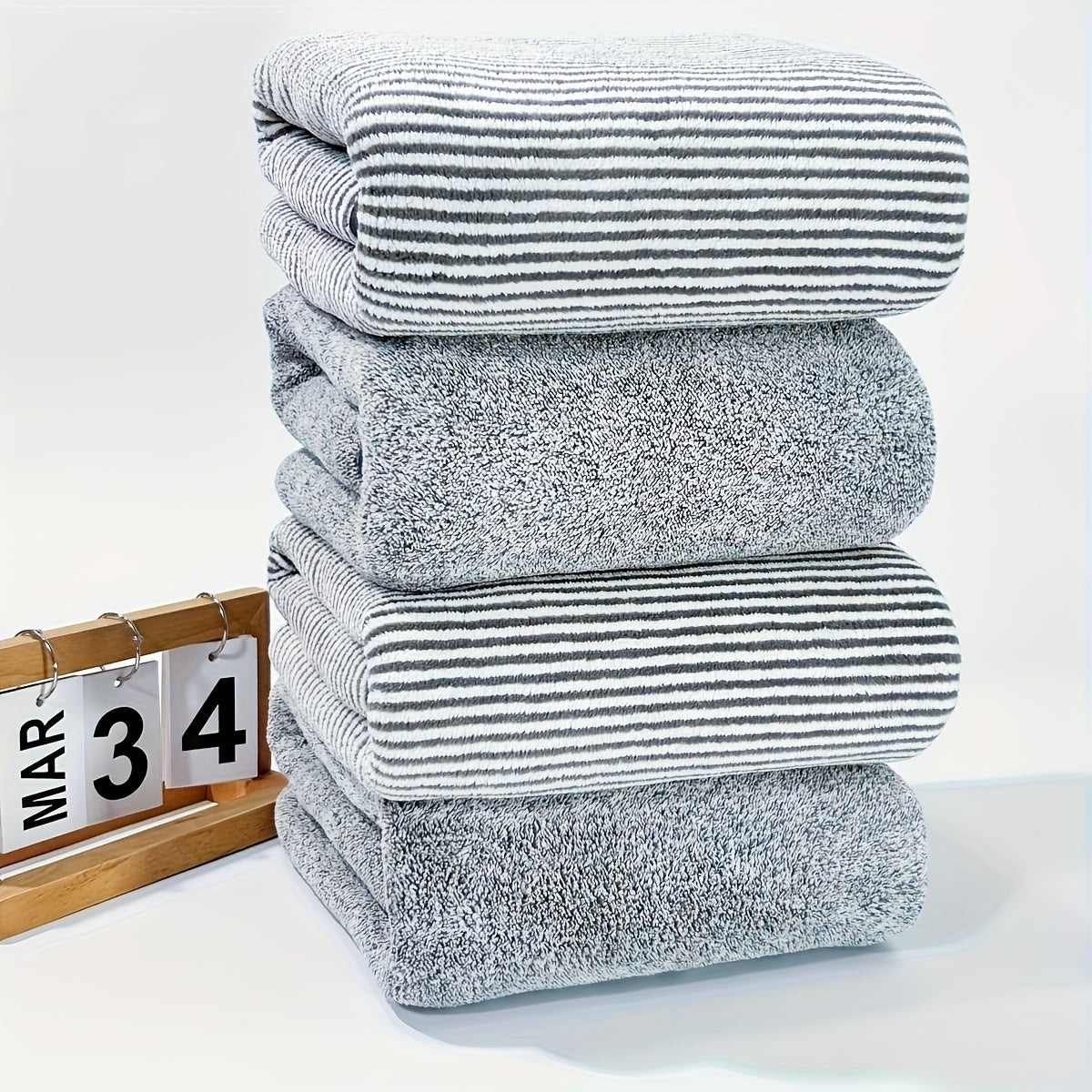 Soft coral fleece towels, 4-piece set with starry stripe design. Highly absorbent and quick-drying for bathroom use.