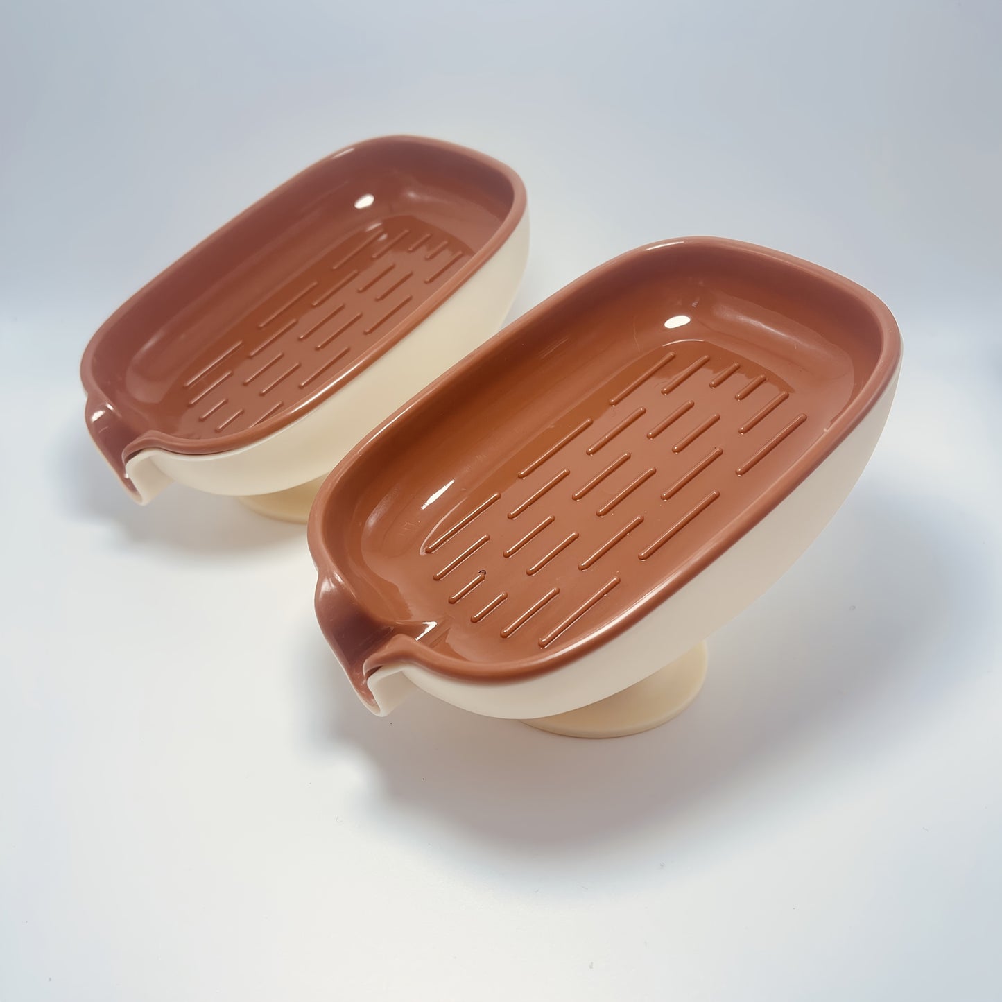 Durable plastic oval soap dish with an elegant, self-draining design for bathroom use.