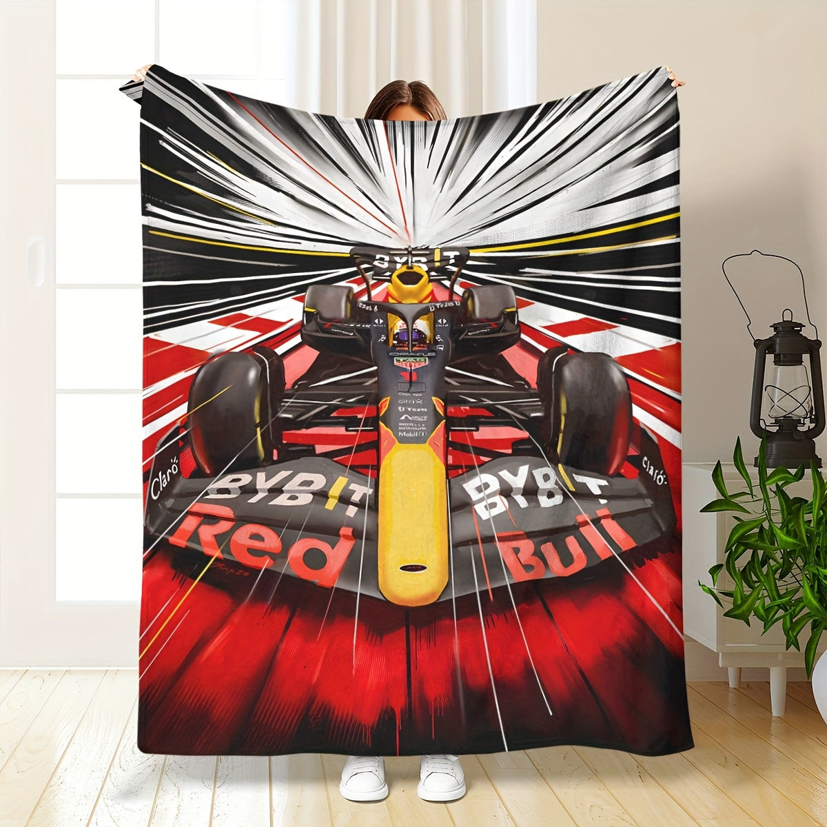 Soft and skin-friendly, this all-season cozy sofa and nap blanket features a dynamic digital design of a vibrant Formula 1 racing car. The blanket is made of flannel and is in red and black with yellow accents.