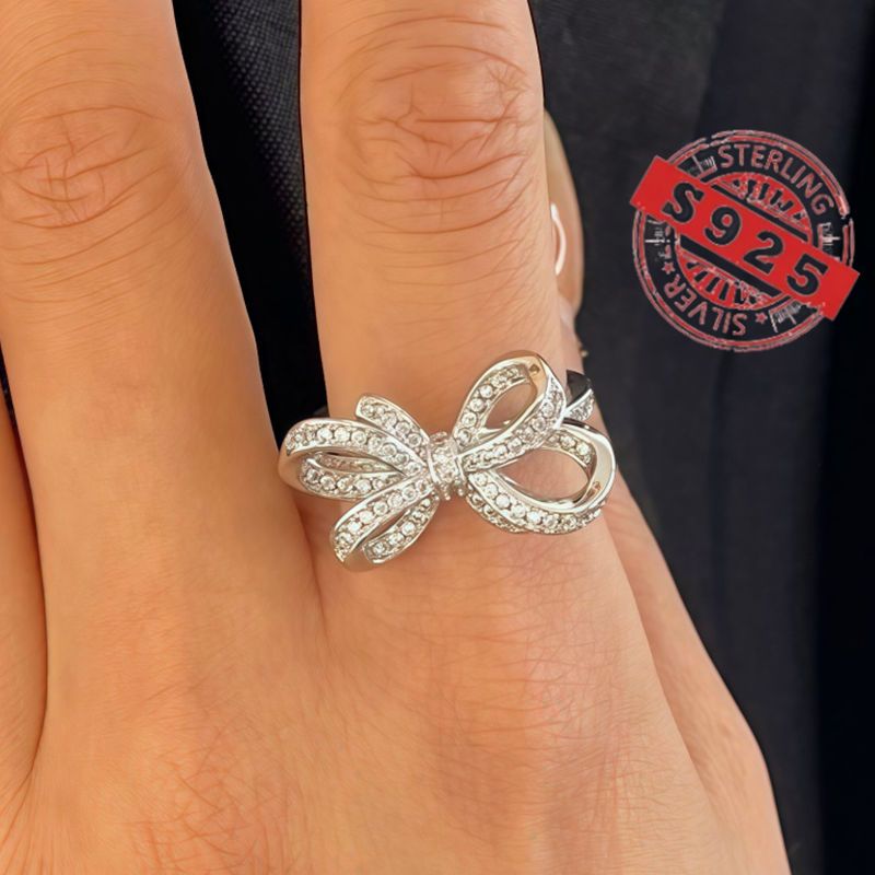 Chic 925 Sterling Silver Ribbon Bow Tie Ring featuring Natural Zirconia, perfect for July Birthdays. This Tribal & Cute style ring is 925 Silver Plated, Tarnish-Resistant, and adorned with Heart-Themed details. Ideal for Daily Wear or Wedding occasions