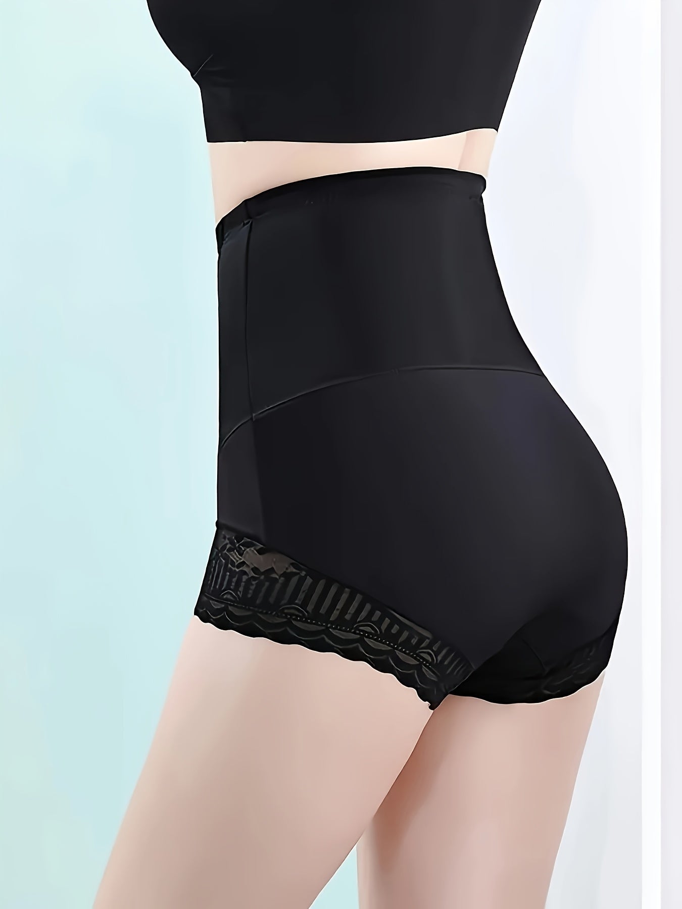 High-waist tummy control shapewear panties for women with postpartum body shaping and seamless knit fabric. Features contrast lace detail and made from polyamide and spandex blend. Solid