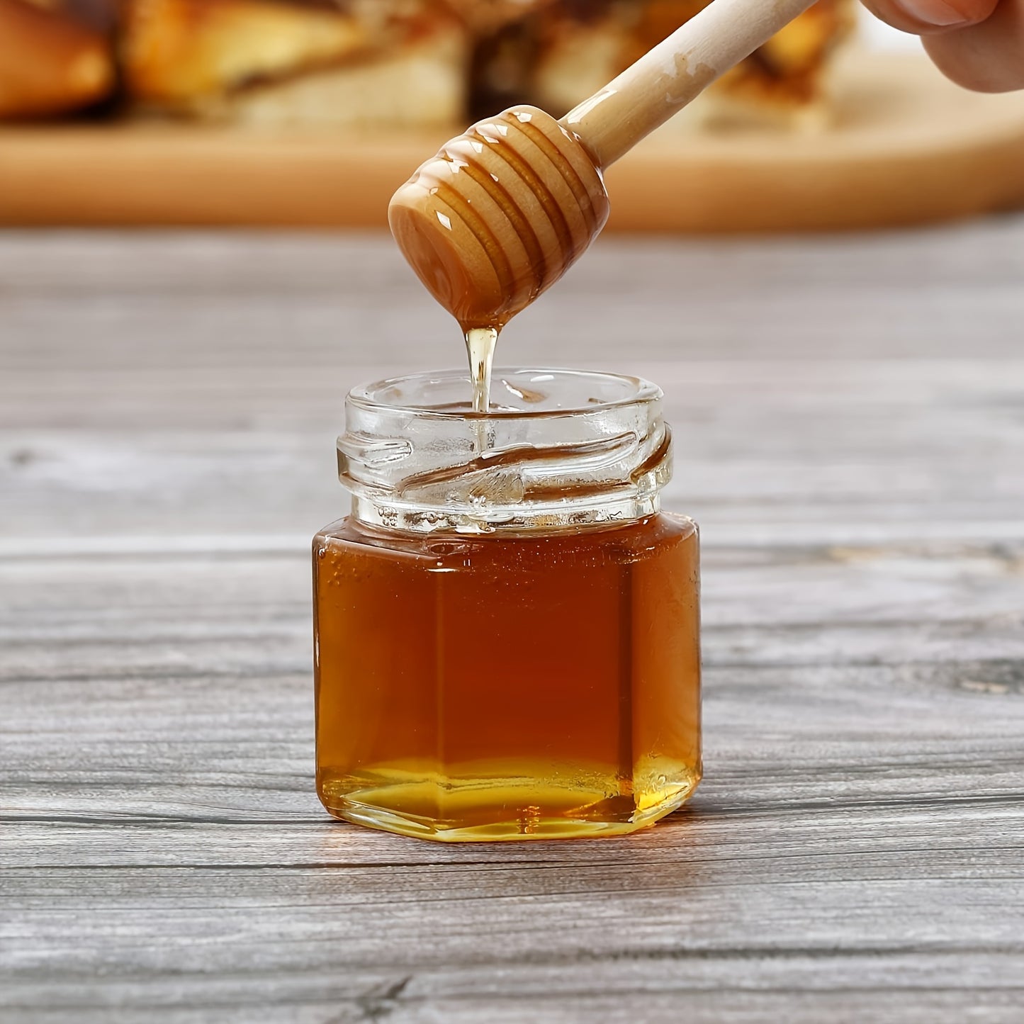 Stylish hexagonal glass jar with gold lid and wooden bucket ideal for preserving food and serving at events. Available in various packaging options for weddings, bridal gifts, and family gatherings. Also great for storing honey creatively.