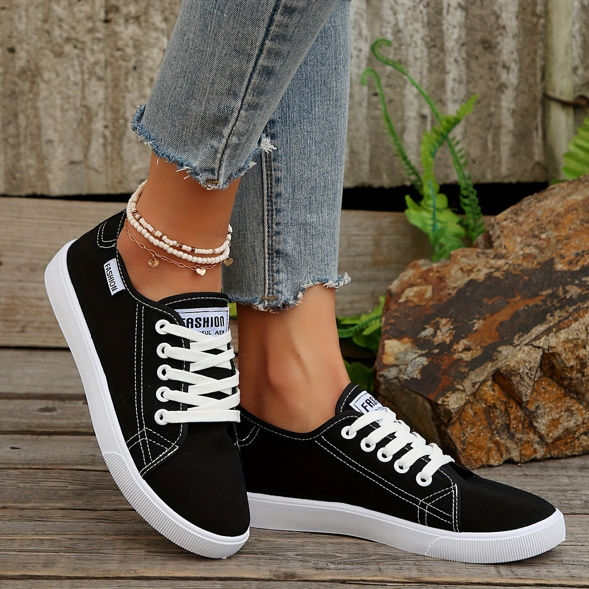 Black & white lace-up sneakers for women with round toe, low-top design, and comfortable EVA sole.