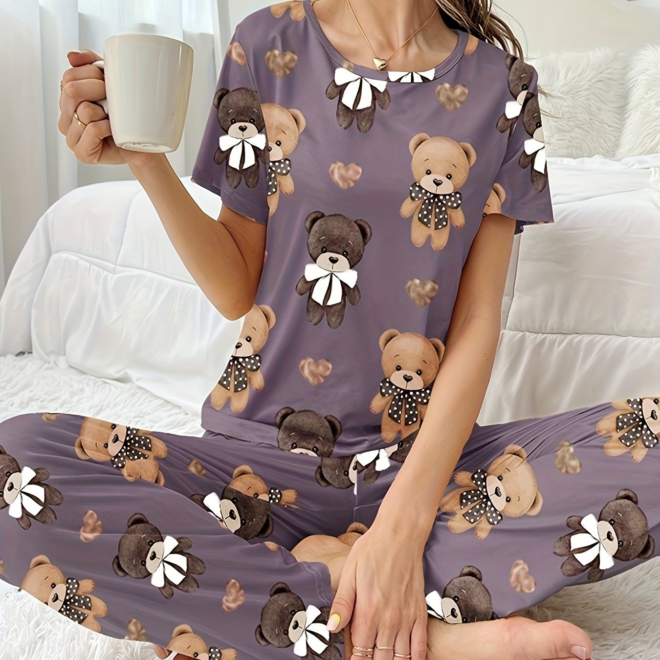 Women's sleepwear set with cartoon bear and heart print, featuring a cozy short sleeve top and elastic pants.