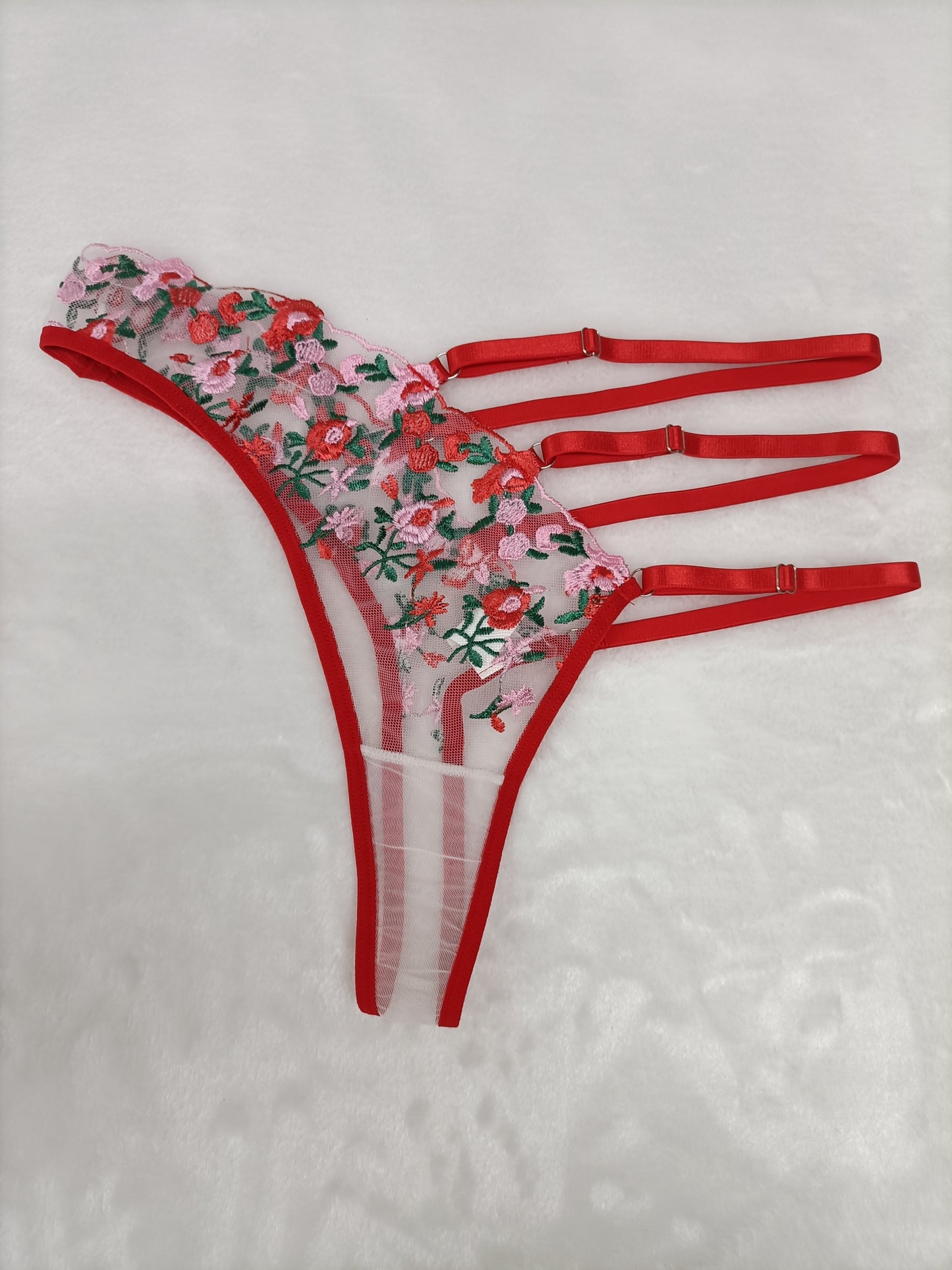 Seductive lace thong panties with sheer mesh and embroidered details, made of 95% polyester and 5% elastane knit fabric for adult intimate wear.